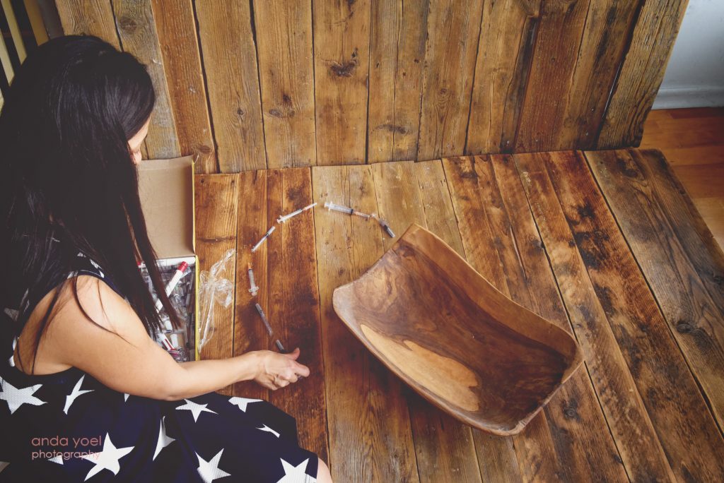 אמא שילדה לאחר טיפולי פוריות מסדרת את במזרקים של הטיפולים בצורת לב - צילום אנדה יואל